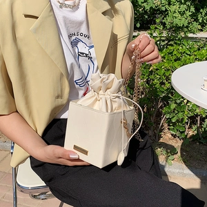 Sac seau crème élégant avec bandoulière chaîne dorée et base carrée structurée
