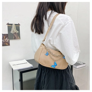 Détail du sac à bandoulière en PU kaki avec chaînes argentées et breloque papillon bleu