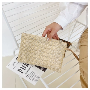 Detail of hand-woven wheat straw clutch with herringbone pattern and zipper strap