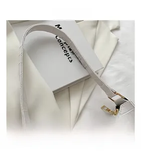 Close-up of white crocodile pattern faux leather bag with gold zipper and metal hardware