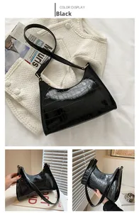 Detail view of black faux crocodile skin pattern on classic crescent shoulder bag