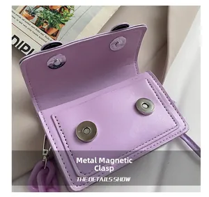 Close-up of purple PU leather mini bag featuring magnetic buckles and resin chain detail