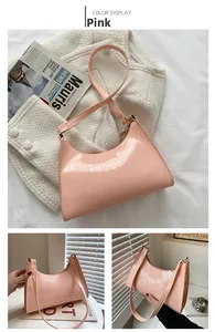 Detail of pink faux crocodile leather shoulder bag with sleek minimalist half moon design