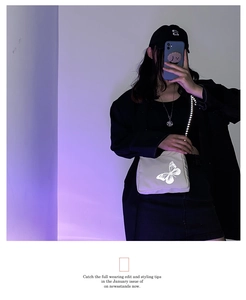 Close-up of beige nylon crossbody bag featuring reflective silver butterfly graphic