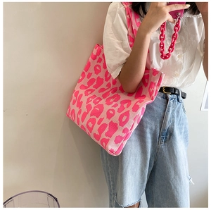 Détail du sac cabas en toile à imprimé léopard rose néon avec bandoulière