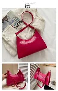 Detail shot of rose pink crescent shoulder bag with crocodile pattern texture