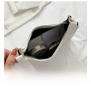 Interior view of white crocodile pattern bag showing space for lipstick and makeup