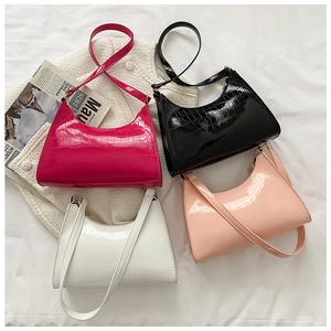 Flat lay of colorful crocodile pattern patent leather shoulder bags on a stylish backdrop