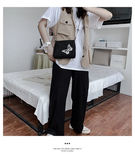 Model wearing a black square oxford crossbody bag with a white butterfly reflective print