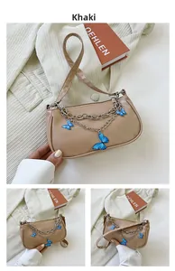 Détail du sac sous l'aisselle kaki avec chaîne argentée et papillon bleu