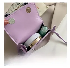 Detail view of purple mini crossbody bag interior showing storage space and chain strap