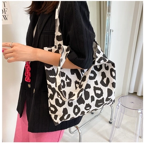 Détail du grand sac cabas en toile avec un imprimé vache noir et blanc très tendance