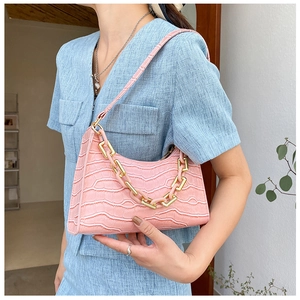 Pink faux crocodile shoulder bag with chunky chain detail worn with blue outfit