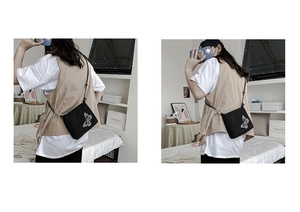 Detail shot of the white butterfly print on the black canvas crossbody bag for women and men