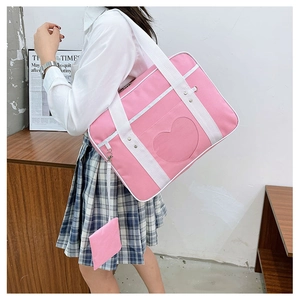 Detail of pink canvas ita bag with heart-shaped transparent window and white straps