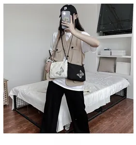 Detail view of black and white crossbody bags with reflective butterfly print in nylon