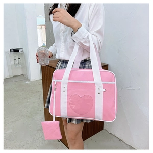 Close-up of pink JK travel bag featuring a heart-shaped clear window and white handles