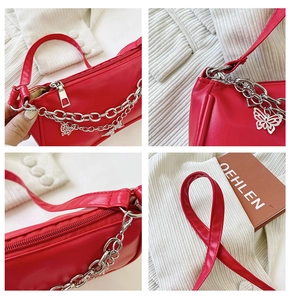 Détail du sac rouge en simili cuir avec pendentif papillon argenté et chaîne en métal