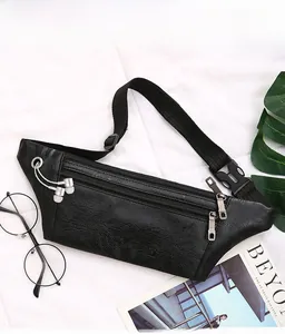 Detail of black lychee grain leather waist bag featuring three zippers and earphone port