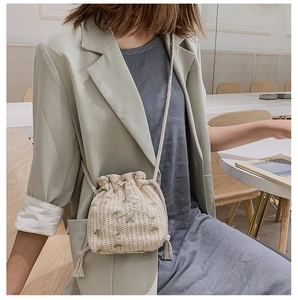 Détail du sac seau tissé beige avec broderie florale et fermeture par cordon serrage