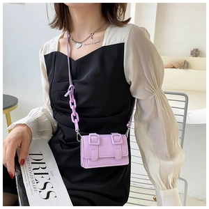 Detail of a purple mini square crossbody bag with double straps and chain handle