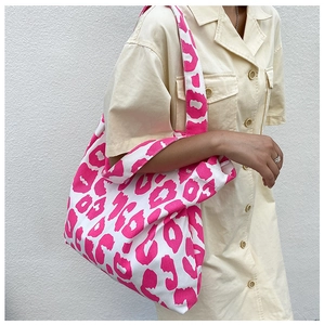 Vue détaillée du sac cabas en toile blanche avec imprimé léopard rose sur modèle