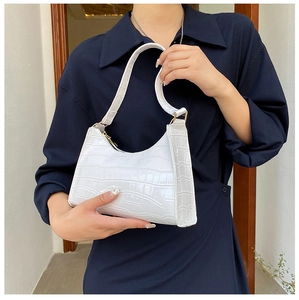 Close-up of white crocodile pattern crescent underarm bag with glossy leather texture