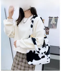Model wearing a large cow print faux fur tote bag for autumn and winter fashion