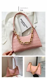 Detailed macro view of pink crocodile pattern underarm bag with gold acrylic chain handle