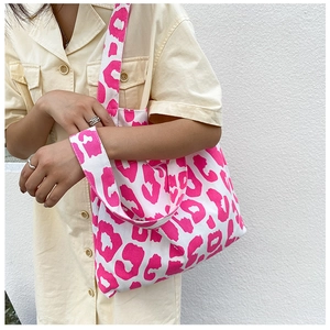 Gros plan d'un sac cabas en toile imprimé léopard rose avec large bandoulière