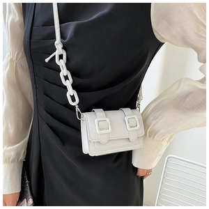 Detail of white mini PU leather crossbody bag with acrylic chain strap on model