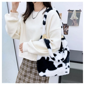 Close-up of the soft plush material and black and white cow print on the shoulder bag
