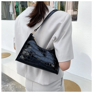 Close-up of black crocodile pattern faux leather underarm bag on shoulder