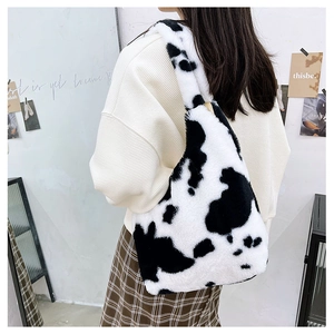 Close-up of fluffy faux fur tote bag with black and white cow print texture details