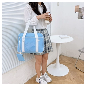 Detail of light blue ITA bag with heart-shaped transparent window and mini coin purse