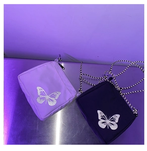 Detail of Y2K reflective butterfly patterns on black and white oxford fabric crossbody bags