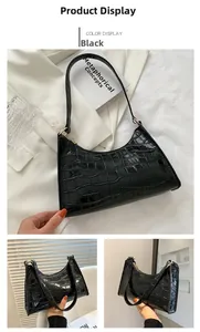 Detail view of the black crocodile pattern texture and zipper closure on this shoulder bag
