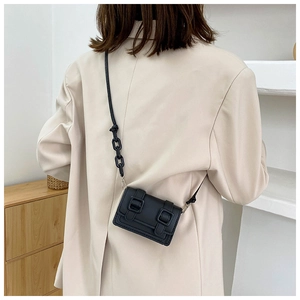 Detailed back view of a mini black leather crossbody bag with vintage double buckles