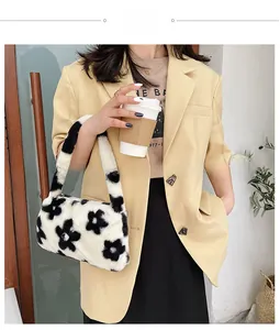 Detalle del bolso de hombro de felpa con estampado de flores blancas y negras y textura suave