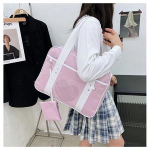 Detailed view of pink heart-shaped itabag window with white canvas straps and small coin purse