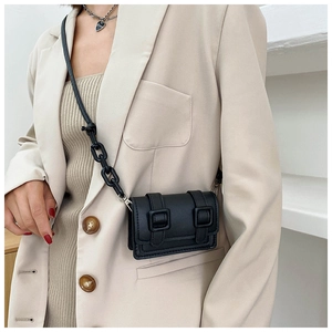 Detail shot of mini black crossbody bag with bold resin chain and double buckles