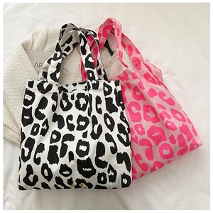 Vue détaillée de sacs cabas en toile à imprimé léopard en noir, blanc et rose fuchsia