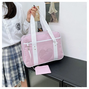 Pink heart window ita bag with white handles shown in a JK school uniform fashion scene