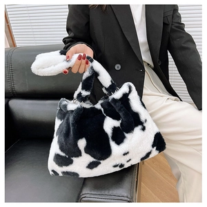Dettaglio della borsa in ecopelliccia con stampa mucca e frange lunghe decorative