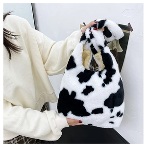 Detailed close-up of cow print faux fur tote bag with soft plush texture and sturdy handles