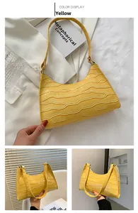 Detail of yellow crocodile embossed faux leather hobo bag with sleek zipper closure