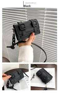 Detail view of a black PU leather crossbody bag featuring dual strap buckles and chain