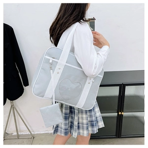 Detail of light blue JK style duffel bag with a heart-shaped clear window and shoulder strap