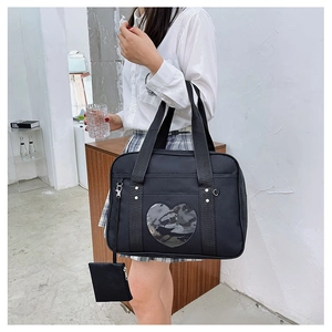 Detail of black JK uniform bag with heart-shaped transparent window and coin pouch