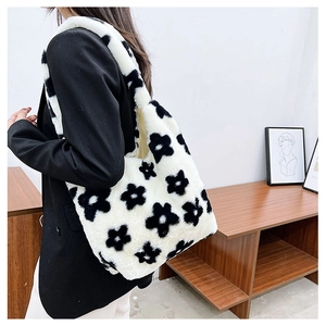 Detail view of the plush floral tote bag with black and white patterns on a female model